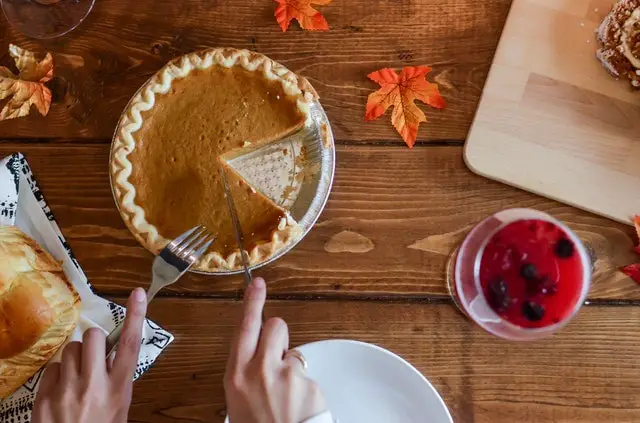 Woman Cutting Slice of Pie With Folk and Knife