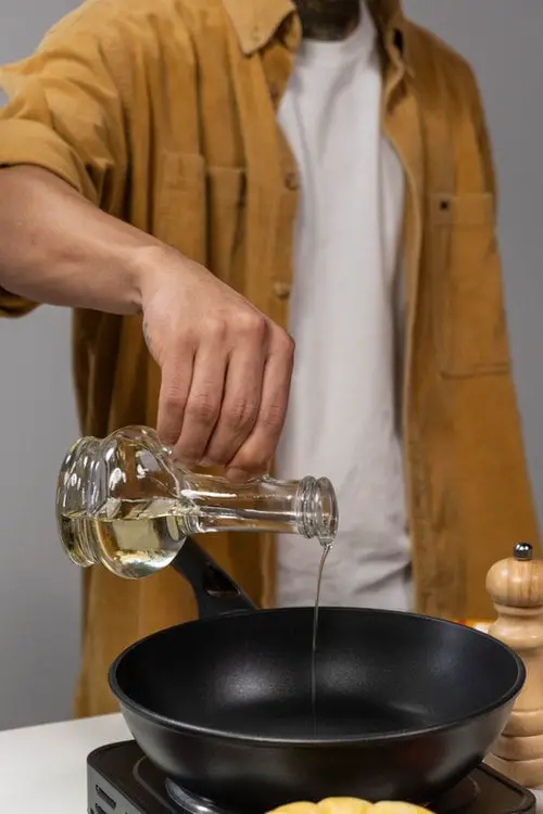 Man pouring oil to the cooking pan